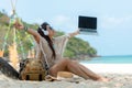 Lifestyle freelance woman raise arms relax after using laptop working on the beach Royalty Free Stock Photo